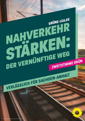 Bahnschienen aus einem fahrenden Zug fotografiert. Davor steht das Banner mit der Aufschrift "Nahverkehr stärken: Der vernünftige Weg – Verlässlich für Sachsen-Anhalt" und dem Hinweis "Zweitstimme Grün"